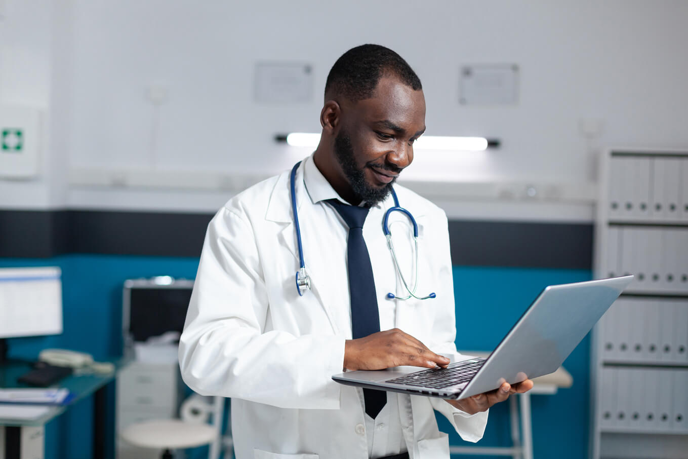 Médico segurando um laptop analisando a prescrição médica on-line.